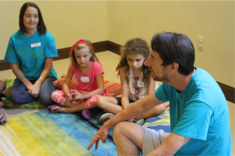 Grief counselors talking with children seated on the floor at New Hope for Kids in Central Florida