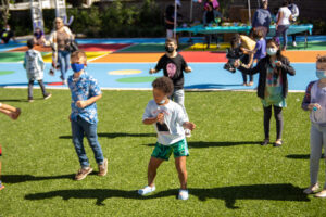Children playing joyfully in the Garden of Hope at New Hope for Kids, surrounded by nature and healing spaces